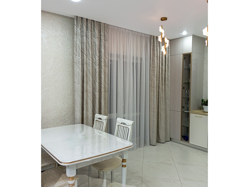 Бежевые шторы с рисунком и белый тюль в интерьере современной столовой