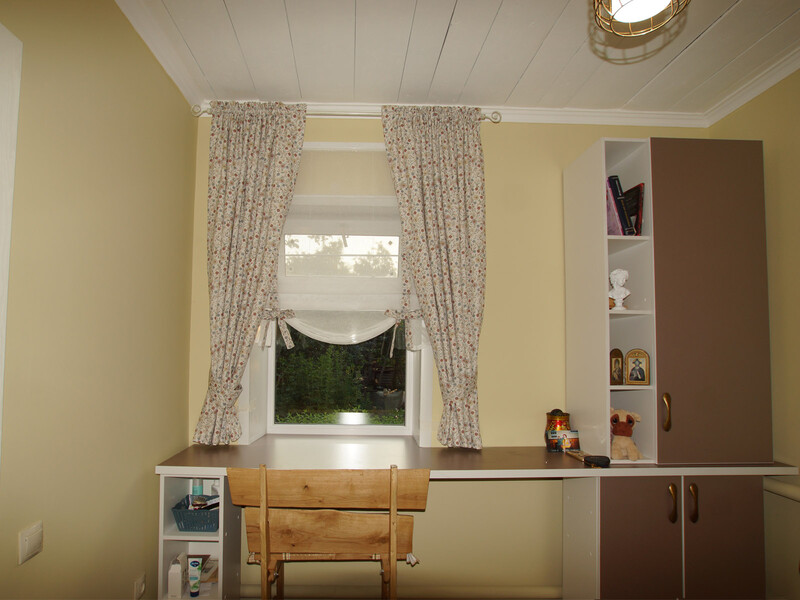 Римская штора и занавески в мелкий цветок в уютной рабочей зоне.